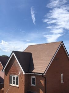 A tiled pitched roof with brown tiles installed on a new build house in Guildford.
