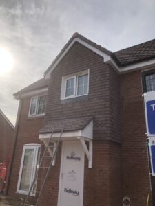 A porch roof installed above the front door of a new build house in Guildford.