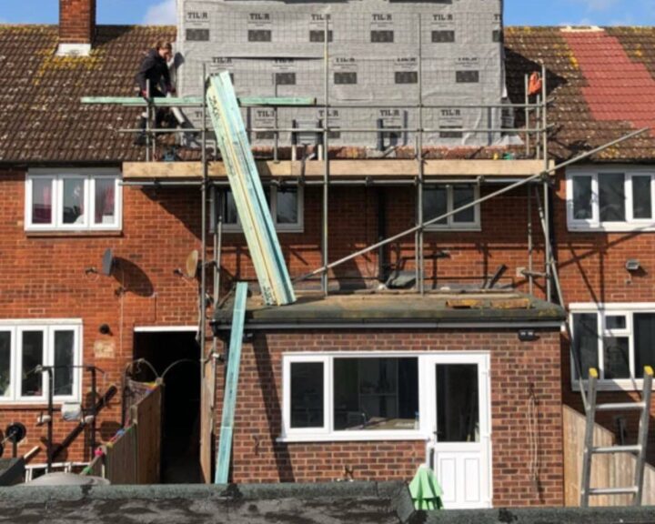 A dormer loft extension being installed on the roof of a house.