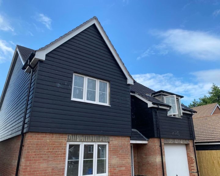 Grey composite cladding installed on the exterior of a residential property in Guildford.